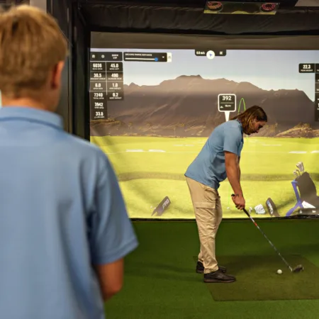 Golfers playing an indoor golf simulator in Batemans Bay