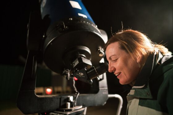 A woman looking through the telescope.
